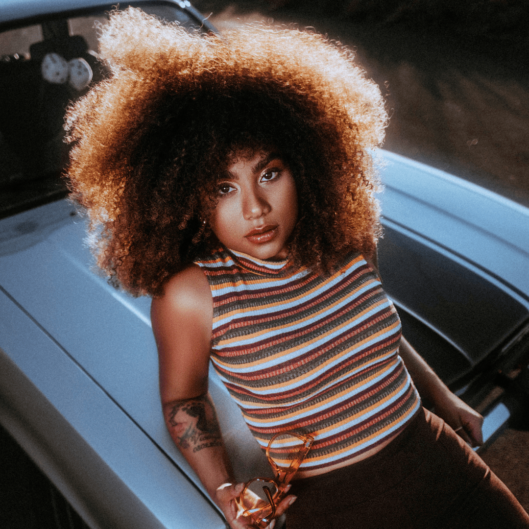 Healthy, full curly hair with balanced volume and shine on woman outdoors