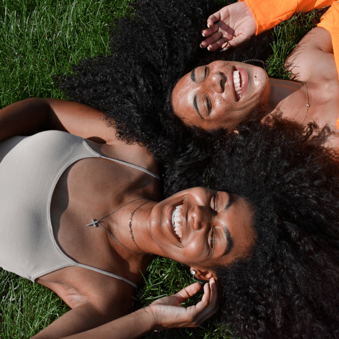 Healthy curly hair with moisture and definition after co-washing, women smiling on lawn